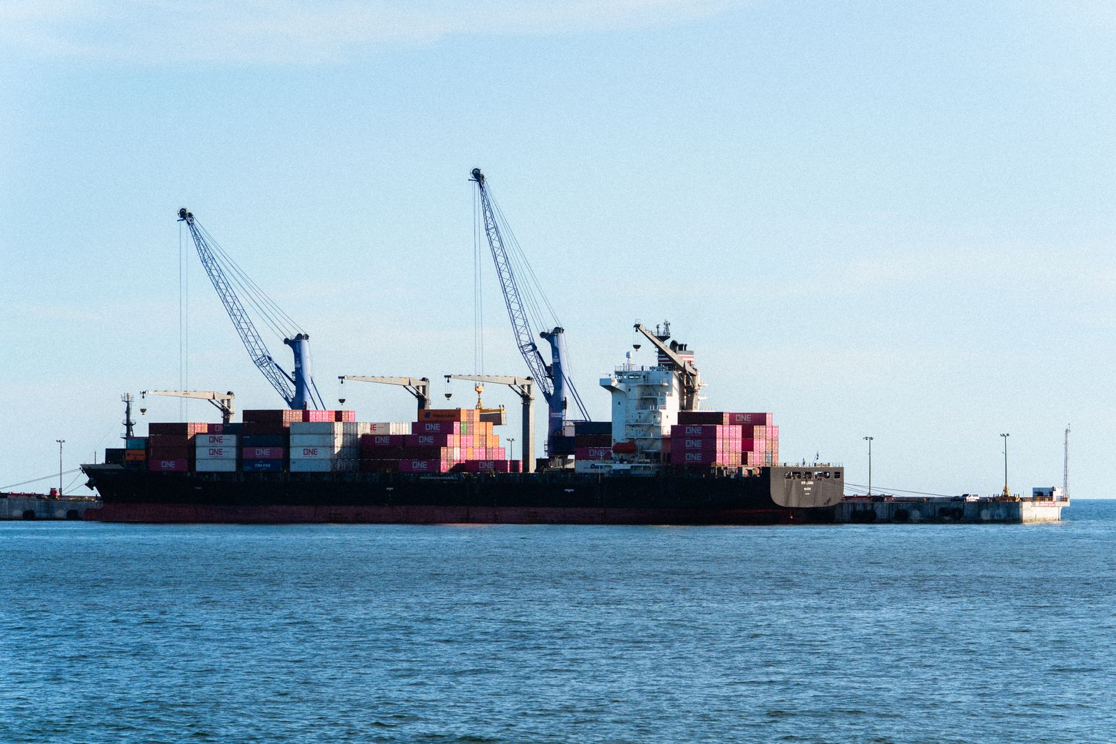 Cargo ship docked at a port with cranes